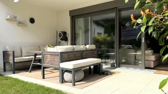 Möblierte Terrasse mit bequemen Sitzgelegenheiten und Zugang zum Garten, ideal für entspannte Stunden im Freien.