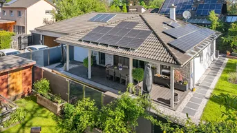 Luftaufnahme des Hauses mit Photovoltaikanlage auf dem Dach und einer großen Terrasse.