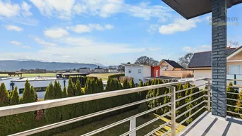 Großer Balkon mit Edelstahlgeländer und weitem Blick über die Landschaft.