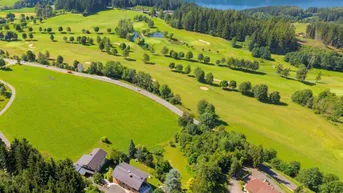 Luftaufnahme der Liegenschaft mit Blick auf den See, Golfplatz und die umliegende Natur.
