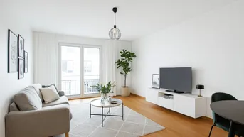 Heller, modern eingerichteter Wohn-Essbereich mit Holzboden und Zugang zum Balkon.