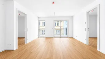 Heller, leerer Raum mit Eichenparkettboden und Zugang zu zwei französischen Balkonen.