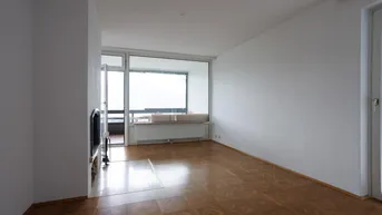 Helles Wohnzimmer mit Parkettboden, Kamin und Zugang zu einem Balkon.