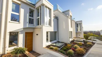 Moderne Architektur mit weißer Fassade, großen Fenstern und gepflegter Gartenanlage.