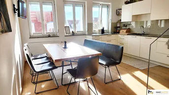 Helle, offene Küche mit Holztisch, modernen Schränken und Parkettboden, ideal für gemeinsame Mahlzeiten.