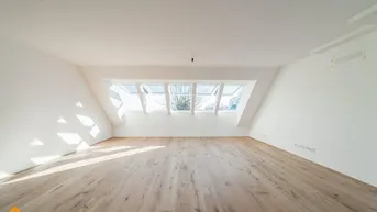 Helles Dachgeschosszimmer mit Holzboden und mehreren Dachfenstern, ideal für Wohn- oder Schlafbereich.