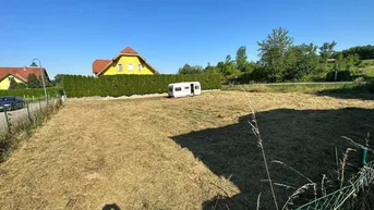 Sonniges Grundstück mit freiem Blick auf die umliegende Landschaft und Nachbarhäuser.