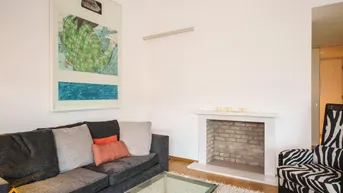 Gemütlicher Wohnbereich mit Sofa, Teppich und einem dekorativen Kamin.