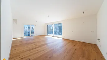 Helles und geräumiges Wohnzimmer mit neuem Parkettboden und Zugang zu einem französischen Balkon.