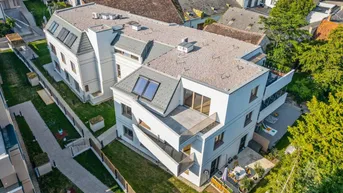 Vogelperspektive des modernen Wohnkomplexes mit Gärten, Terrassen und Flachdächern.