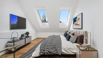 Helles Schlafzimmer im Dachgeschoss mit Holzboden, Dachfenstern und Blick auf den Kirchturm.
