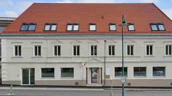 Ansicht der modernen Gebäudefassade mit vielen Fenstern und rotem Ziegeldach.