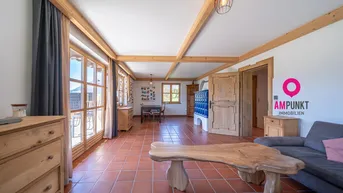 Geräumiger Wohn-Essbereich mit Terrakottafliesen, Holzbalken und traditionellem Kachelofen.