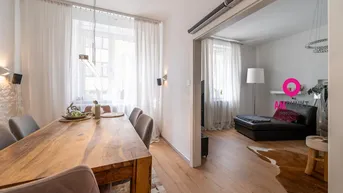 Heller Essbereich mit großem Holztisch und Zugang zum Wohnzimmer, ausgestattet mit modernen Leuchten.