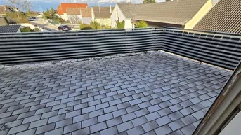 Geflieste Terrasse mit Sichtschutz und Blick auf die Nachbarschaft.