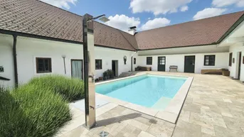 Innenhof mit großem Swimmingpool, Außendusche und gepflasterter Terrasse.