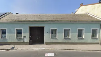 Einfamilienhaus mit hellblauer Fassade, Satteldach und Solaranlage auf dem Dach.