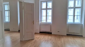 Heller, leerer Raum mit hohen Fenstern und Parkettboden, bereit für die individuelle Gestaltung.