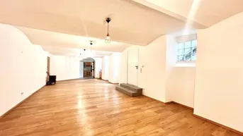 Geräumiger, heller Raum mit Holzboden und gewölbter Decke, ideal für vielseitige Nutzung.