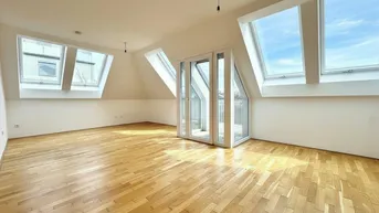 Helles Dachgeschosszimmer mit Parkettboden und mehreren Dachfenstern, bietet viel natürliches Licht.