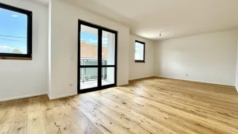 Helles, leeres Wohnzimmer mit Holzboden und Zugang zum Balkon, ideal für individuelle Gestaltung.