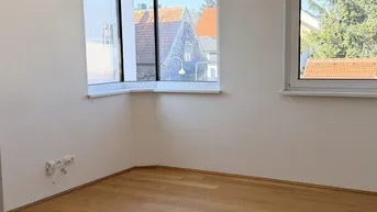 Helles Schlafzimmer mit Eichenparkett, weißen Wänden und einem praktischen Eckfenster.