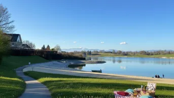 Idyllische Lage am See mit Bergblick und weitläufigen Grünflächen, perfekt für Erholung und Freizeit.