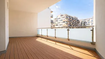 Geräumiger Balkon mit Holzboden und Glasgeländer, bietet einen sonnigen Platz im Freien mit Stadtblick.