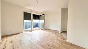 Helles, leeres Zimmer mit Holzboden und Zugang zu einem Außenbereich, ideal als Wohnzimmer.