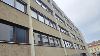 Mehrstöckiges Wohngebäude mit zahlreichen Fenstern und einer strukturierten Fassade.