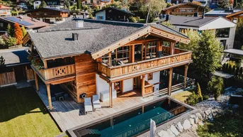 Luxuriöses Holzchalet mit privatem Pool, großzügigen Balkonen und Garten in alpiner Umgebung.