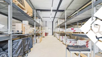 Geräumige Lagerhalle mit hohen Decken, Metallregalen und Betonboden, ideal für Logistik und Lagerung.