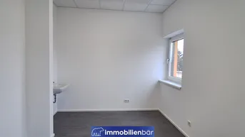 Heller Büroraum mit einem Fenster und einem kleinen Waschbecken, ideal für eine Einzelnutzung.