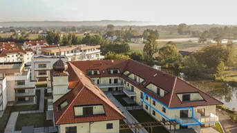 Luftaufnahme des Anwesens mit mehreren Gebäuden, umgeben von Grünflächen und einem Gewässer.