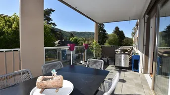Geräumiger Balkon mit Esstisch, Grill und weitem Blick auf die grüne Landschaft.