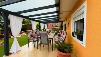Überdachte Terrasse mit Essbereich und Loungemöbeln, ideal für entspannte Stunden im Freien.