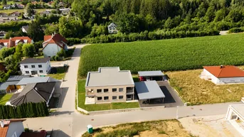 Weitläufige Luftaufnahme des Wohngebäudes mit Carports, umgeben von Feldern und ländlicher Umgebung.