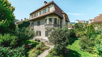 Historisches Stadthaus mit gepflegtem Vorgarten und sonnigem Rasenbereich.