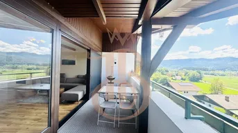 Überdachter Balkon mit Esstisch und Stühlen, bietet einen weiten Blick auf die umliegende Natur.