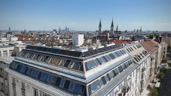 Panoramablick über die Stadt Wien mit historischen Gebäuden und moderner Dacharchitektur.