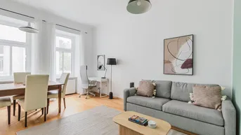 Helles Wohn- und Esszimmer mit Holzboden, modernem Sofa und Esstisch.