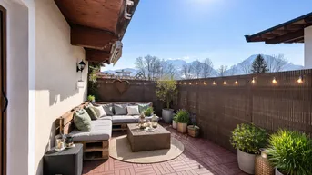 Gemütliche Sonnenterrasse mit Loungemöbeln, Bergblick und Lichterkette für entspannte Abende.