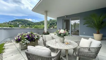 Geräumige Terrasse mit Sitzgelegenheiten, Blumenkästen und weitem Blick auf die grüne Umgebung.