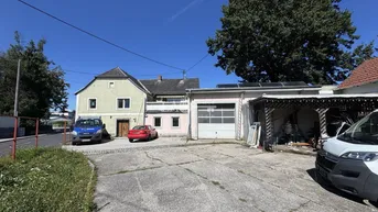 Gesamtansicht des Anwesens mit Wohnhaus, Werkstatt und gepflastertem Vorplatz.