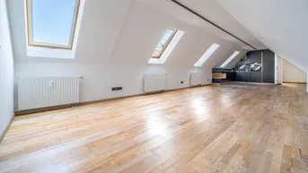 Heller Dachgeschossraum mit Holzboden, Heizkörpern und mehreren Dachfenstern, bereit zur individuellen Gestaltung.