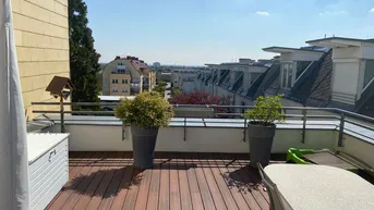 Große Dachterrasse mit Holzboden, Pflanzen und weitem Blick über die Stadt.