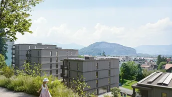 Moderne Wohngebäude in einer grünen Umgebung mit weitem Blick auf die umliegende Berglandschaft.