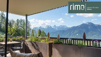 Geräumige Terrasse mit bequemen Sitzgelegenheiten, Sonnenschutz und atemberaubendem Bergblick.