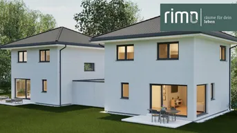 Moderne Doppelhaushälfte mit großen Fenstern und Terrasse im Grünen.