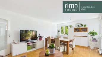 Helles Wohn- und Esszimmer mit Parkettboden, modernen Möbeln und Blick ins Grüne.